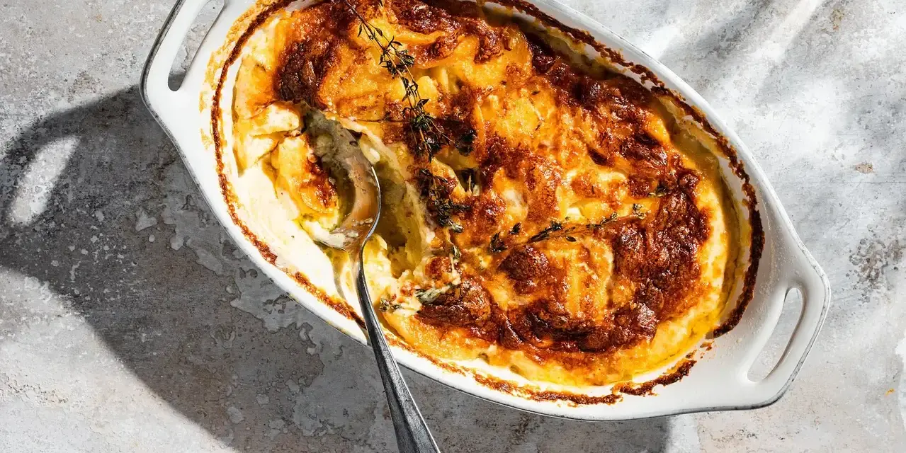 Ein goldbraunes Kartoffelgratin mit Kräutern, bereit zum Servieren. Dieses Kartoffelgratin Rezept ist ein Genuss!