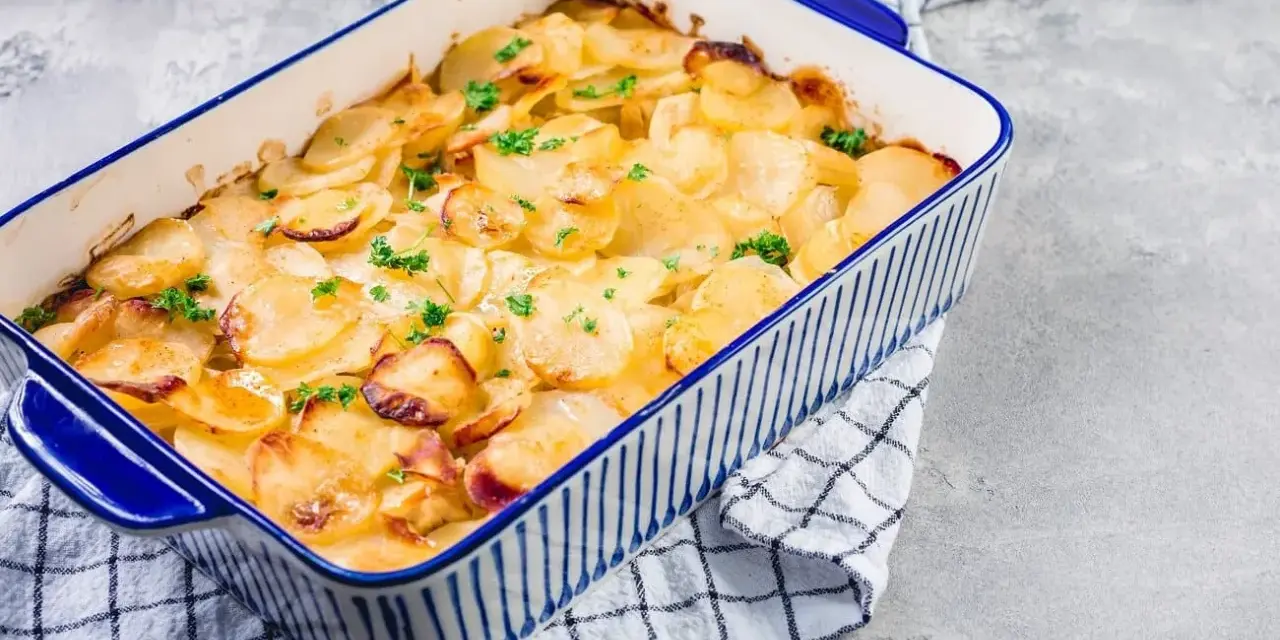 Ein goldbrauner Kartoffelauflauf, garniert mit Petersilie, bereit zum Servieren. Ein köstliches Kartoffelauflauf Rezept.