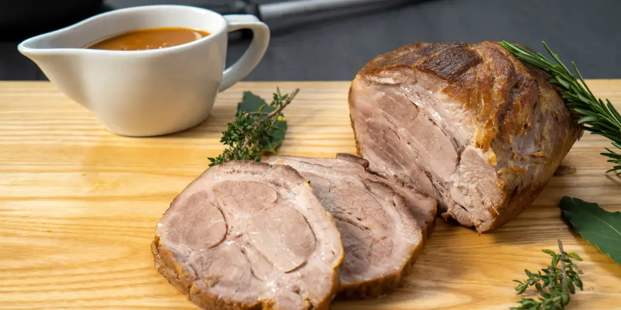 Saftiger Schweinenacken, aufgeschnitten und mit Soße serviert. Ein köstliches Schweinenacken Rezept für jeden Anlass.