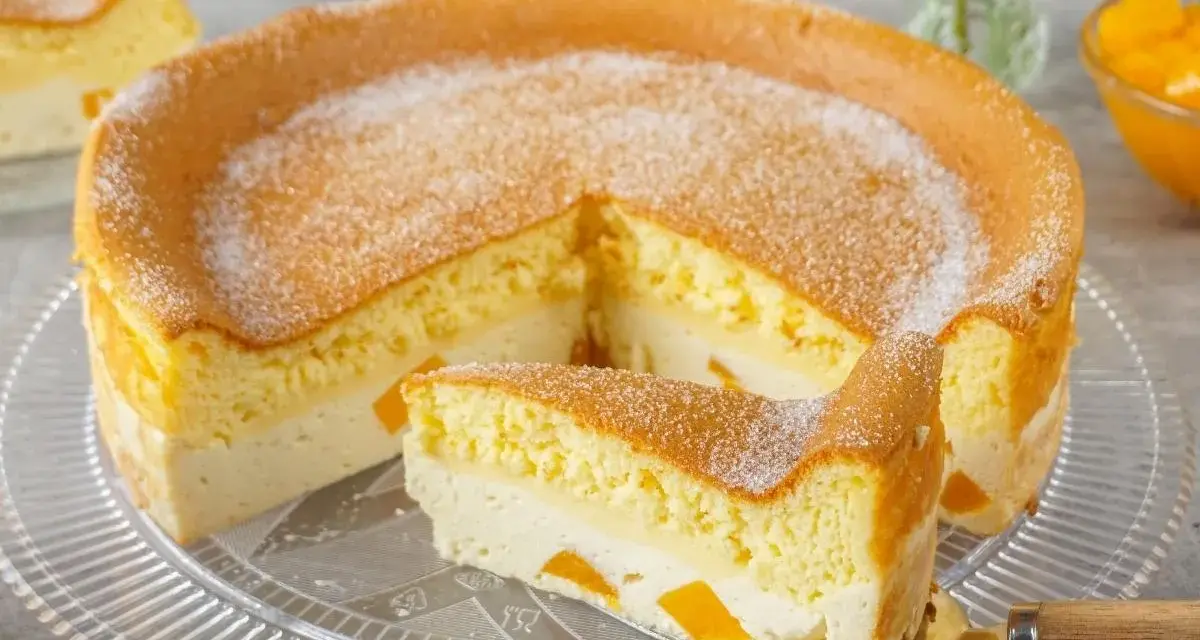Luftige Eierschecke ohne Boden, mit einer cremigen Füllung und saftigen Fruchtstücken, bestäubt mit Puderzucker.