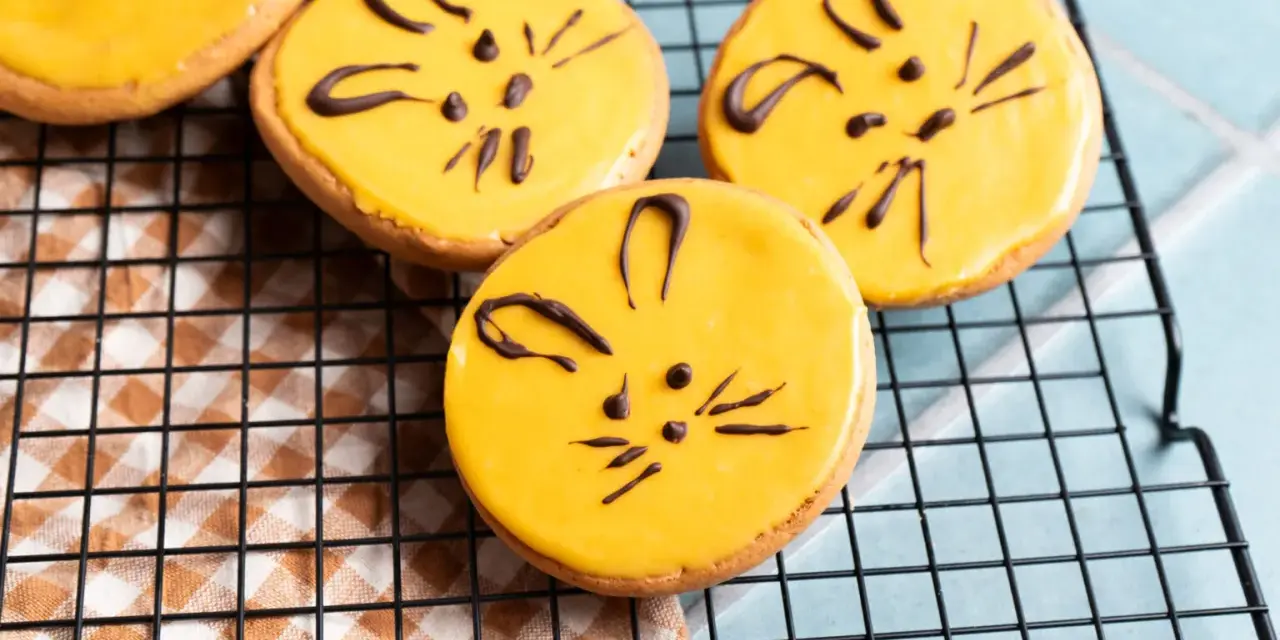 Süße Kekse mit gelber Glasur und Schokoladen-Katzenmotiven, ein tolles amerikaner rezept für Kinder.