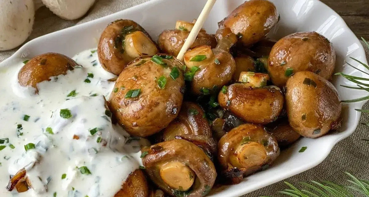 Herzhafte Champignons wie vom Weihnachtsmarkt, glasiert und mit Kräutern bestreut, serviert mit cremiger Sauce.