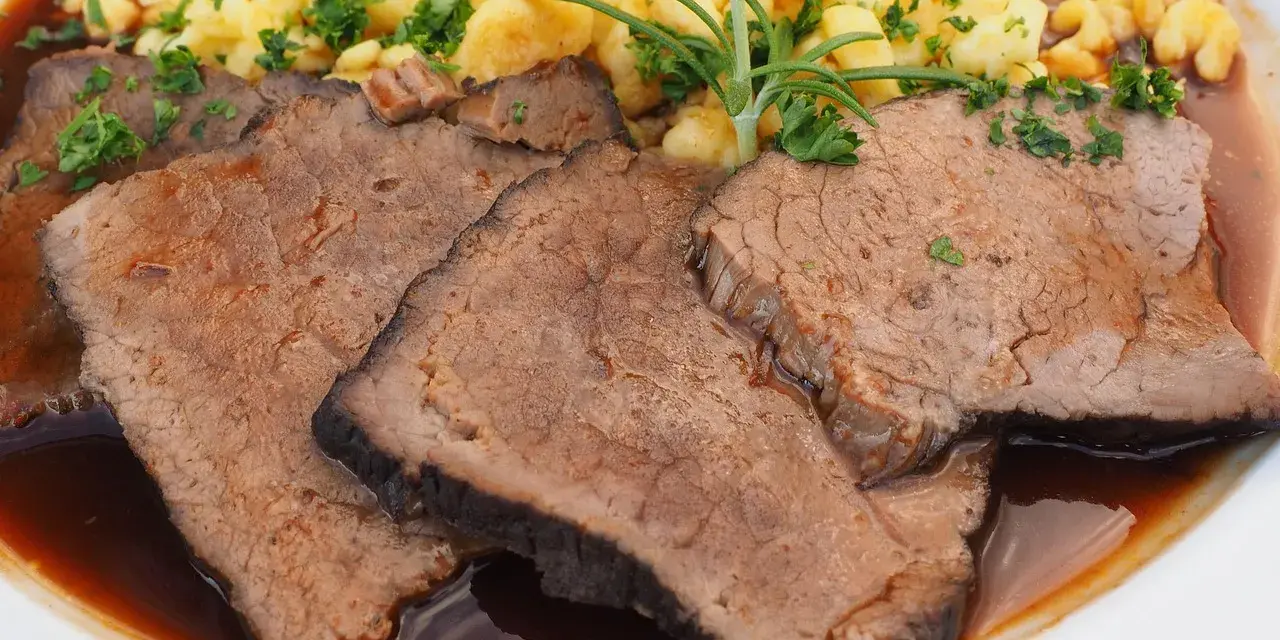 Saftige Scheiben Sauerbraten mit Spätzle und einer Kräutergarnitur. Ein klassisches Sauerbraten Rezept, das Appetit macht.