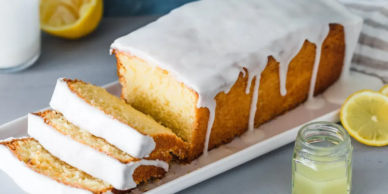 Saftiger Zitronenkuchen mit Zuckerguss, perfekt für ein einfaches zitronenkuchen rezept. Serviert mit frischen Zitronenscheiben.