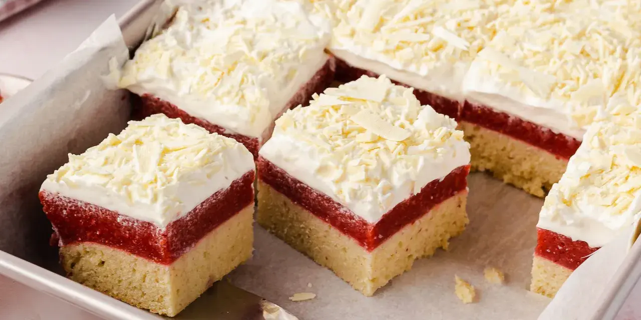 Schichtkuchen mit roter Fruchtschicht, weißer Creme und Schokostreuseln – perfekt als Kuchen zum Muttertag.