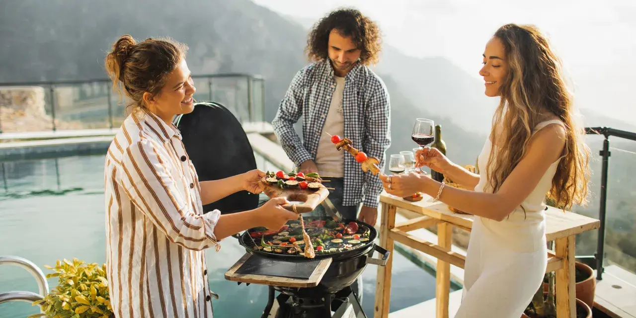 Freunde genießen ein Grillfest mit Gemüse-Spießen, das an einen Maggi Salat erinnert.