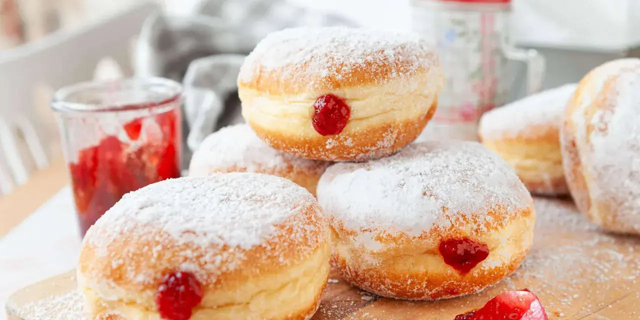 Frisch gebackene Krapfen im Airfryer, mit Puderzucker bestäubt und Marmelade gefüllt. Ein süßer Genuss!