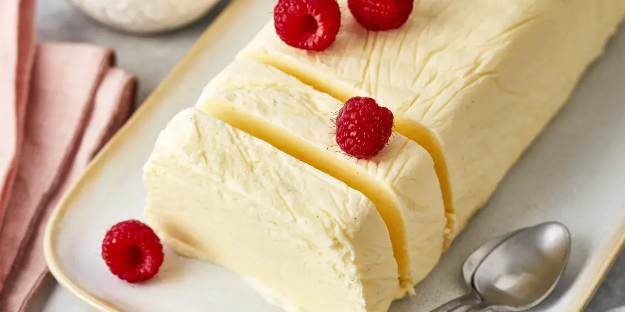 Cremiger Rhabarber Pudding, dekoriert mit frischen Himbeeren, auf einem Teller mit Löffeln.