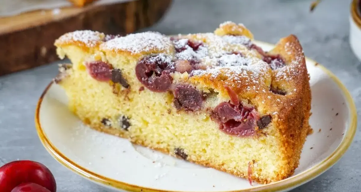 Ein saftiges Stück Kirschkuchen, bestäubt mit Puderzucker. Dieses Kirschkuchen Rezept ist ein Genuss!