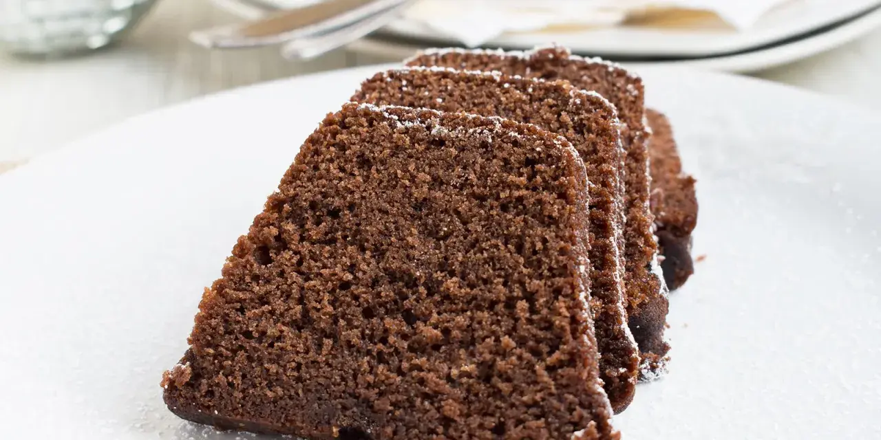 Saftige Scheiben eines Schokoladenkuchens, bestäubt mit Puderzucker. Ein köstlicher Nutella Kuchen, bereit zum Genießen.