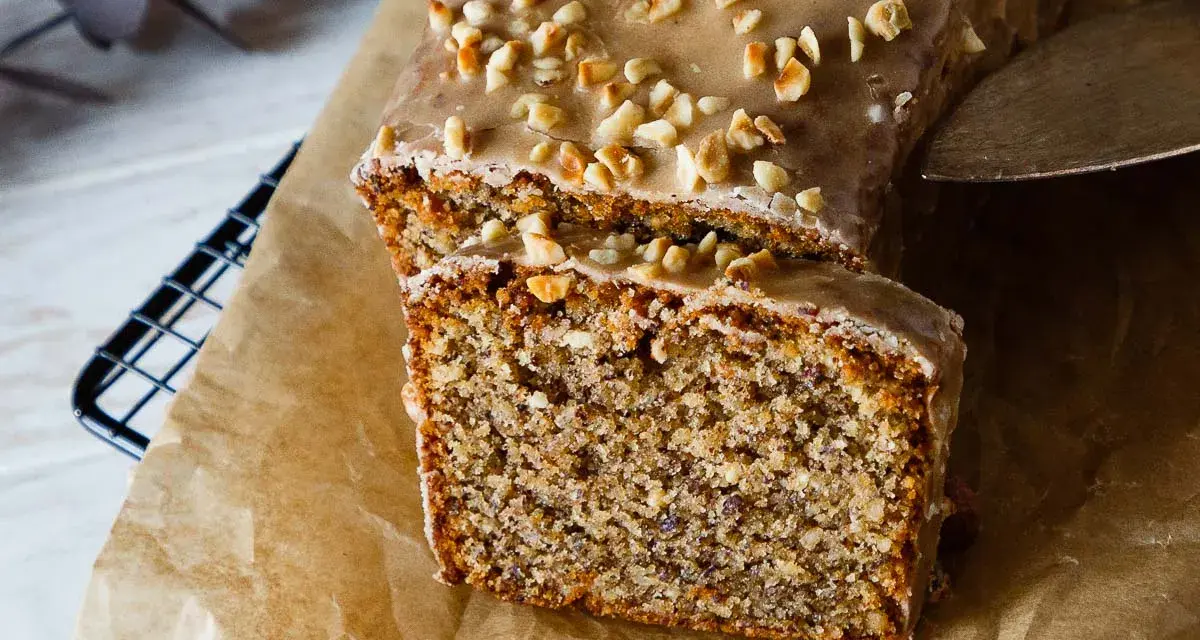 Saftiger Nusskuchen mit Zuckerguss und gehackten Nüssen, perfekt für ein gemütliches Kaffeetrinken. Ein tolles Nusskuchen Rezept!