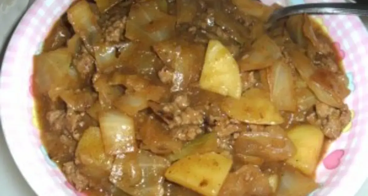Herzhaftes Schichtkraut Rezept mit Hackfleisch und Kartoffeln in einer deftigen Sauce, serviert auf einem pink-weiß karierten Teller.
