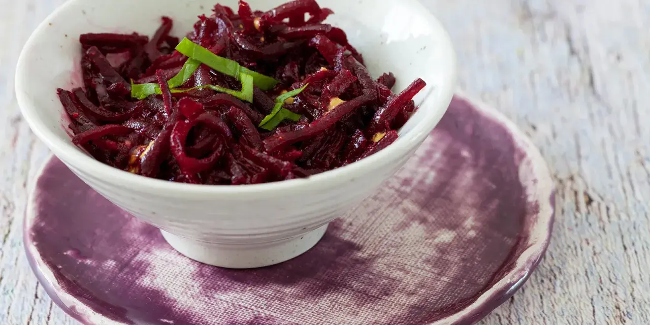 Rote Bete Salat nach Omas Art, ein herzhaftes Gericht mit fein geschnittenen Rote Bete, garniert mit frischen Kräutern.