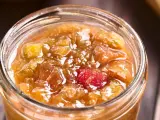 Ein Glas mit leuchtend rotem und goldenem Rhabarber-Chutney, bereit zum Genießen.