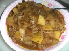 Herzhaftes Schichtkraut Rezept mit Hackfleisch und Kartoffeln in einer deftigen Sauce, serviert auf einem pink-weiß karierten Teller.
