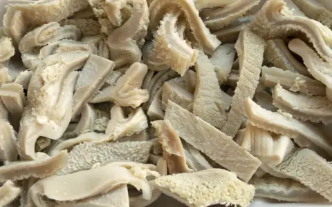 Gekochte und geschnittene Kutteln für ein herzhaftes Kutteln Rezept. Die Textur ist faserig und leicht wellig.