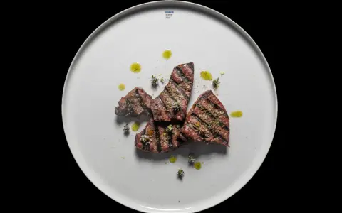 Gebratene Leberstücke mit Kräutern und Olivenöl auf einem weißen Teller. Ein einfaches, aber köstliches Leber Rezept.