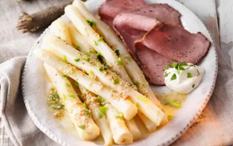 Schwarzwurzeln zubereitet mit zerstoßenen Nüssen und Schnittlauch, serviert mit Roastbeef und einem Klecks Kräuterquark.