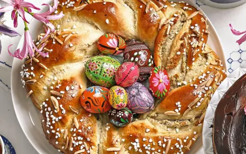 Bunter Osterkranz mit verzierten Eiern und Mandelsplittern, perfekt zum Backen zu Ostern.