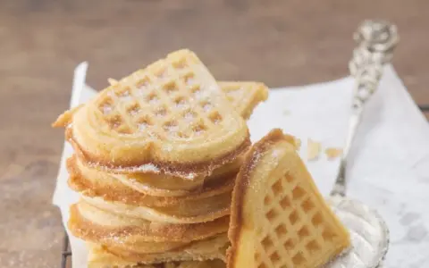 Herzförmige Waffeln, bestäubt mit Puderzucker. Ein perfektes Rezept für süße Momente.