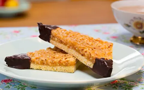 Zwei Nussecken mit Schokoladenspitze auf einem Teller, bereit zum Genießen. Ein köstliches nussecken rezept.