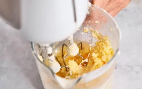 Hand mixt Sahne zu Butter. Der Prozess, um Butter selber machen, ist faszinierend.