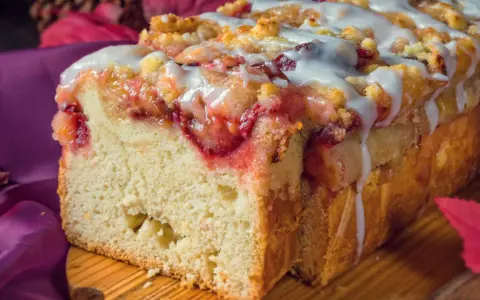 Saftiger Pflaumenkuchen in Kastenform, mit Streuseln und Zuckerguss überzogen, bereit zum Genießen.