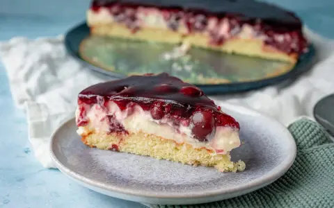 Ein saftiges Stück Kirsch-Sahne-Torte auf einem Teller, perfekt für ein schnelles obstkuchen rezept in der springform.