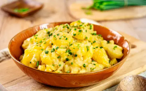 Ein köstlicher Kartoffelsalat, perfekt für jedes Kartoffelsalat Rezept. Mit frischen Kräutern garniert, bereit zum Servieren.