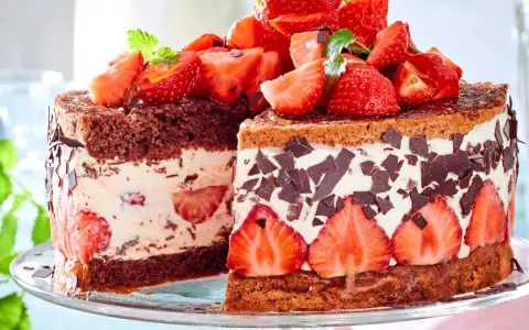 Ein saftiger Erdbeerkuchen mit Quarkfüllung, dekoriert mit frischen Erdbeeren und Schokoladenstückchen.
