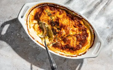 Ein goldbraunes Kartoffelgratin mit Kräutern, bereit zum Servieren. Dieses Kartoffelgratin Rezept ist ein Genuss!