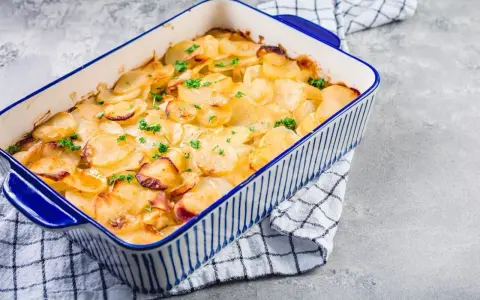 Ein goldbrauner Kartoffelauflauf, garniert mit Petersilie, bereit zum Servieren. Ein köstliches Kartoffelauflauf Rezept.