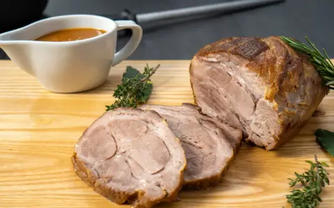 Saftiger Schweinenacken, aufgeschnitten und mit Soße serviert. Ein köstliches Schweinenacken Rezept für jeden Anlass.