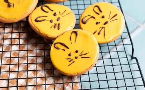 Süße Kekse mit gelber Glasur und Schokoladen-Katzenmotiven, ein tolles amerikaner rezept für Kinder.