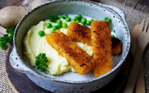 Knusprige Fischstäbchen auf cremigem Kartoffelbrei mit Erbsen und Petersilie – schnelle Gerichte mit Kartoffelbrei, die immer schmecken.