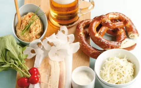 Herzhaftes bayerisches Vesper: Brezn, Bier, Obatzda, Radieschen und der weltbester Krautsalat.