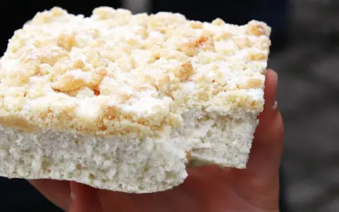 Ein Stück Kuchen mit Streuseln, die ohne Butter zubereitet wurden, liegt auf einer Hand.