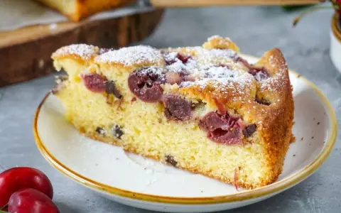 Ein saftiges Stück Kirschkuchen, bestäubt mit Puderzucker. Dieses Kirschkuchen Rezept ist ein Genuss!