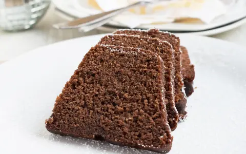 Saftige Scheiben eines Schokoladenkuchens, bestäubt mit Puderzucker. Ein köstlicher Nutella Kuchen, bereit zum Genießen.