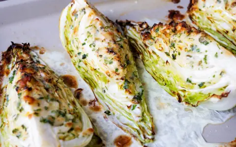 Gegrillte Spitzkohl-Spalten mit Kräutern und Käse, ein köstliches Gericht, das Lust auf mehr Spitzkohl Rezepte macht.