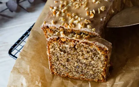 Saftiger Nusskuchen mit Zuckerguss und gehackten Nüssen, perfekt für ein gemütliches Kaffeetrinken. Ein tolles Nusskuchen Rezept!
