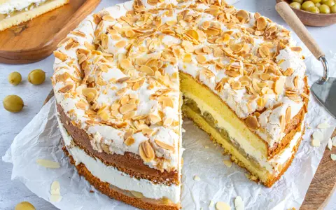Ein köstlicher Stachelbeer Baiser Kuchen mit Mandelsplittern und einer luftigen Baiserhaube.