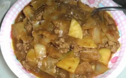 Herzhaftes Schichtkraut Rezept mit Hackfleisch und Kartoffeln in einer deftigen Sauce, serviert auf einem pink-weiß karierten Teller.