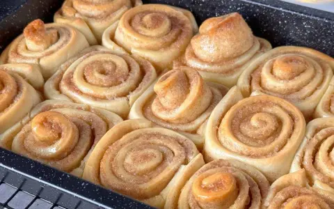 Frisch gebackene Zimtschnecken im Blech, bereit für das Zimtschnecken Rezept. Goldbraun und duftend.