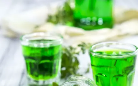 Grüne Gläser mit Waldmeistersirup, perfekt zum Waldmeistersirup selber machen. Frische Kräuter und ein Hauch von Frühling.