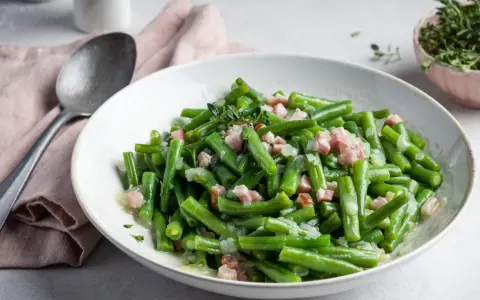 Ein leckeres Brechbohnen Rezept mit Speck und Zwiebeln, garniert mit frischem Thymian.