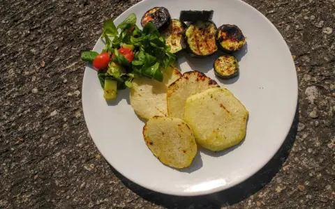 Gegrillte Kohlrabi-Scheiben mit Zucchini und einem kleinen Salat. Ein leckeres Gericht, das Lust auf Kohlrabi grillen macht.