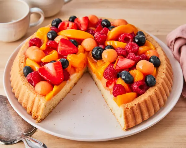 Ein leckerer Obstboden belegt mit Erdbeeren, Himbeeren, Blaubeeren, Aprikosen und Melonenbällchen.