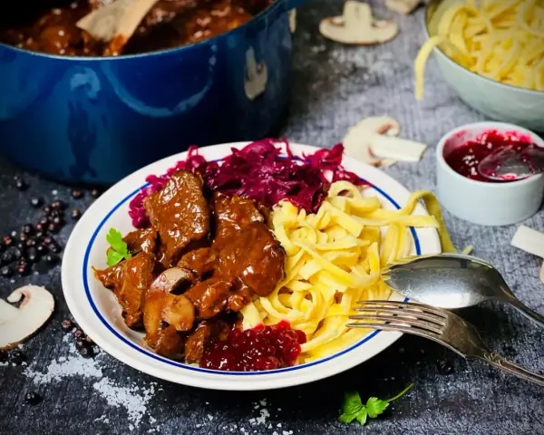 Herzhaftes Rehgulasch mit Spätzle, Rotkohl und Preiselbeeren. Ein köstliches Rehgulasch Rezept für Genießer.