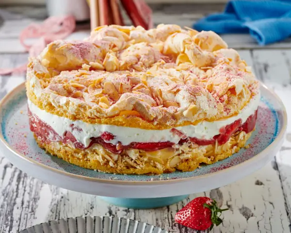Ein köstlicher Rhabarberkuchen mit Baiser, wie ihn Landfrauen backen. Mit Mandelsplittern und roter Puderzucker-Deko.